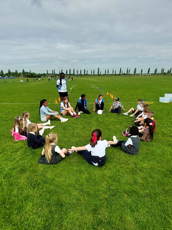 Children sitting in a circle on the grass